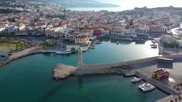 Aerial drone video of unique old picturesque Venetian port with old lighthouse in the heart of famous city of Rethymno at sunset, Crete island, Greec