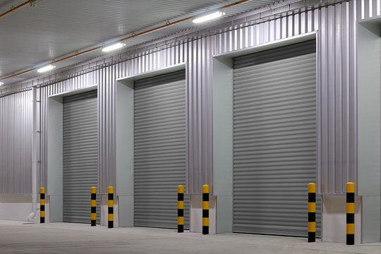 Automatic roller shutter and metal security door at a factory, warehouse, workshop, shop or garage, durable industrial access system for safety, property protection and facility management.