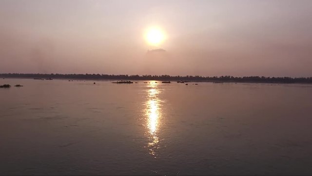 Alluring view of Sap lake during sunset. Golden color reflection on the water. Bright orange sun in the back ground.