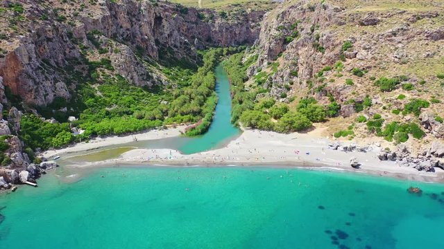 Aerial drone video of Preveli paradise palm beach and lagoon with Palm trees in the South from city of Rethymno, Crete, Greece