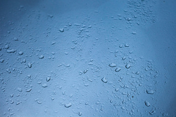 Gotas de água em vidro com fundo azul