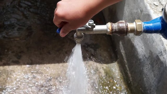 fast flowing water from tap, wasting water, close-up fast flowing tap,