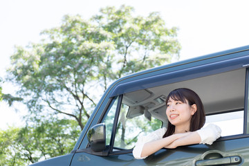 車窓から乗り出し外を眺める女性