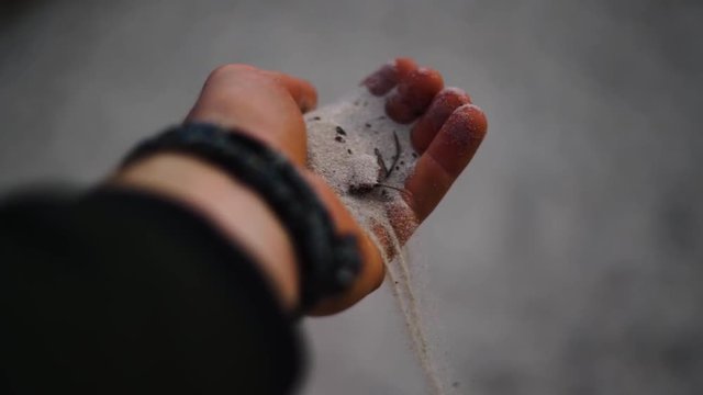 Hand holding the finest sand in the world for hourglasses from Dueodde Strand, Denmark. And letting it flow through his fingers.