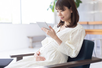 室内でくつろぐ妊婦　タブレット
