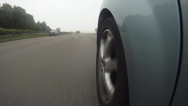A highly stylized clip of a car speeding down the highway on the German autobahn. Highway wheel ungrade.d