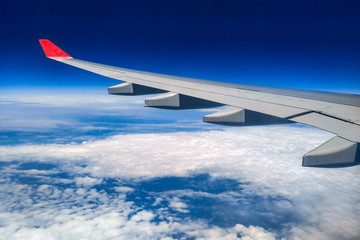 Fototapeta premium wing of an airplane flying above the clouds