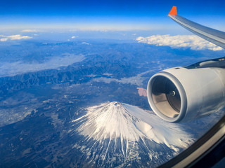 During the morning journey on the plane, the top view from the plane's window overlooking mount fuji in Japan