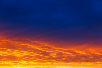 Naklejka na ściany i meble Beautiful sunset. Colorful dramatic sky at sunset. Layered rain clouds. Bright blue orange background. The texture of the sunset. The sky at sunset as the sea and lava.