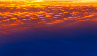 Obraz premium Beautiful sunset. Colorful dramatic sky at sunset. Layered rain clouds. Bright blue orange background. The texture of the sunset. The sky at sunset as the sea and lava.