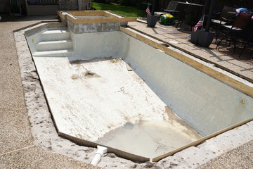 Empty swimming pool under remodel with wooden forms for new tile and coping and concrete