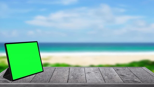 Green screen display on table on beach sae background.