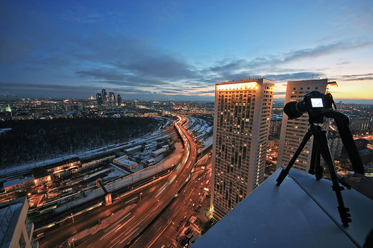 camera on the edge of the roof, shooting panoramas of Moscow at sunset