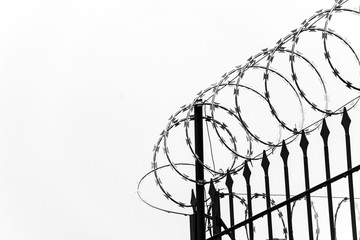 Cerca de arame farpado com c&eacute;u cinzento de fundo