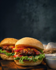 Delicious 2 home made hamburger with beef, ketchup, mustard and fresh vegetables served on wooden board. Free space for text