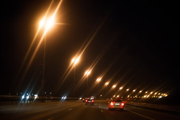 Fototapeta na wymiar black night road highway with yellow lights and cars