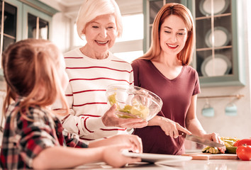 Obraz na płótnie Canvas Happy senior woman preparing dinner for her family