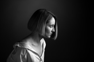 Fototapeta na wymiar Dramatic black and white portrait of a beautiful woman on a dark background