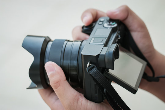 Production  movie video concept : Professional videographer or photographer holding mirrorless camera shooting take photo or video for recording at outdoor. Process media films concept