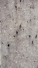 Background of weathered concrete wall with tiny holes.