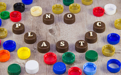No plastic. Inscriptions in wooden letters on plastic bottle caps.