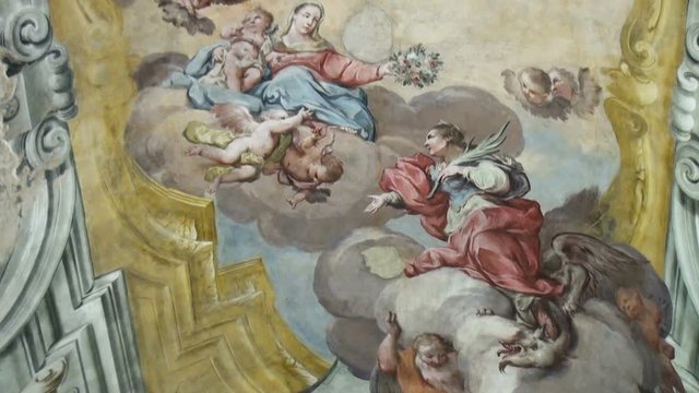 Fragments of biblical stories painted on the arched ceiling in the antique desecrated italian christian temple