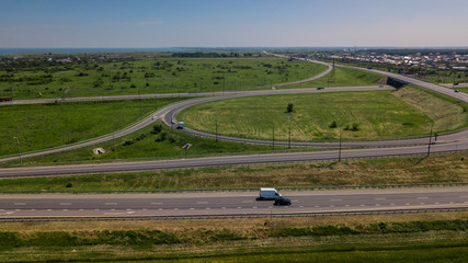 Aerial view of modern highway road intersection on rural landscape