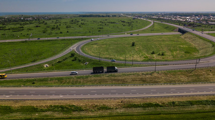 Aerial view of modern highway road intersection on rural landscape
