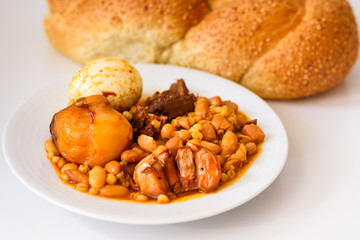 Challah Shabbat bread and hamin or cholent in hebrew - Sabbath traditional food on white table in the kitchen.Top view.