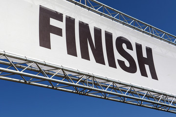 Finish line banner across a clear blue sky