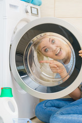 Woman looking inside of washing machine