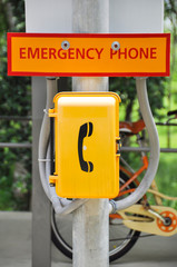 Emergency phone box beside urban street for urgent call.