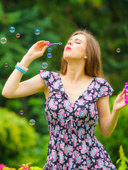 Woman blowing soap bubbles, having fun
