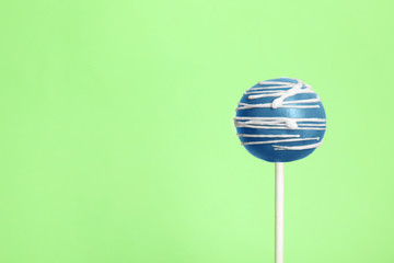 Bright delicious cake pop on color background. Space for text
