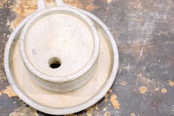 Top view of ancient stone flour mill on black wooden table.