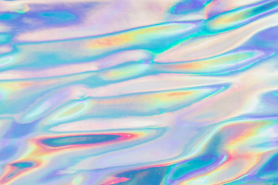 Holographic Foil Texture.  Abstract soft pastel iridescent background. Rainbow color sunlight spots. Cyberpunk