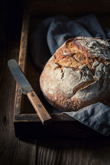 Healthy loaf of bread in dark rutic wooden table
