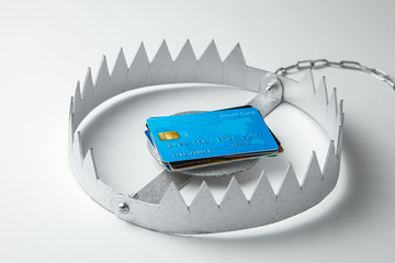 Trap with stack of credit cards. Unsafe credit risk. Gray background.