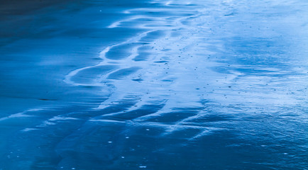 Wet coastal sand. Abstract blue toned photo