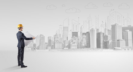 Young supervisor architect standing and replanning a big city panorama
