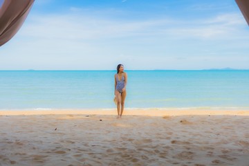 Fototapeta na wymiar Portrait beautiful young asian woman happy smile relax on the tropical beach sea ocean for leisure travel