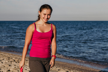 Fototapeta premium Slender tanned girl playing badminton on beach