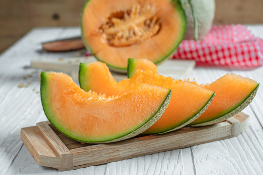 Fresh Of Whole And Sliced Orange Melon Or Cantaloupe On Tray Board And Background Wooden Table. Favorite Fruit In Summer Concept.