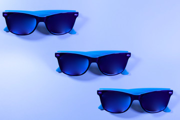 Three pairs of blue glasses on a blue background