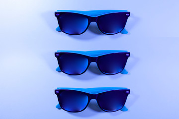 Three pairs of blue sunglasses in a row