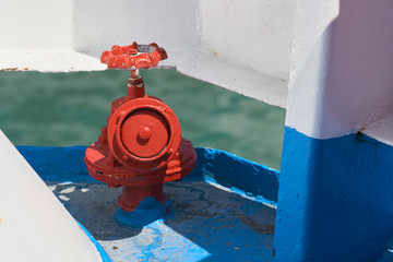 Close Up Of A Red Painted Water Hydrant Fire Hose On Deck Of An Old Ferry Boat.
