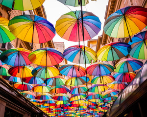 Fototapeta na wymiar Colorful umbrellas in the sky of the Victoria Passage, in Bucharest city centre, Romania