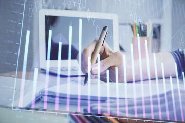 Financial forex charts displayed on woman's hand taking notes background. Concept of research. Double exposure