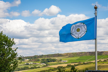 The White Rose of York flag blowing in the wind overlooking the Yorkshire Countryside