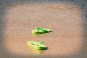 colored sandals on the shore of the beach, summer and vacation concept